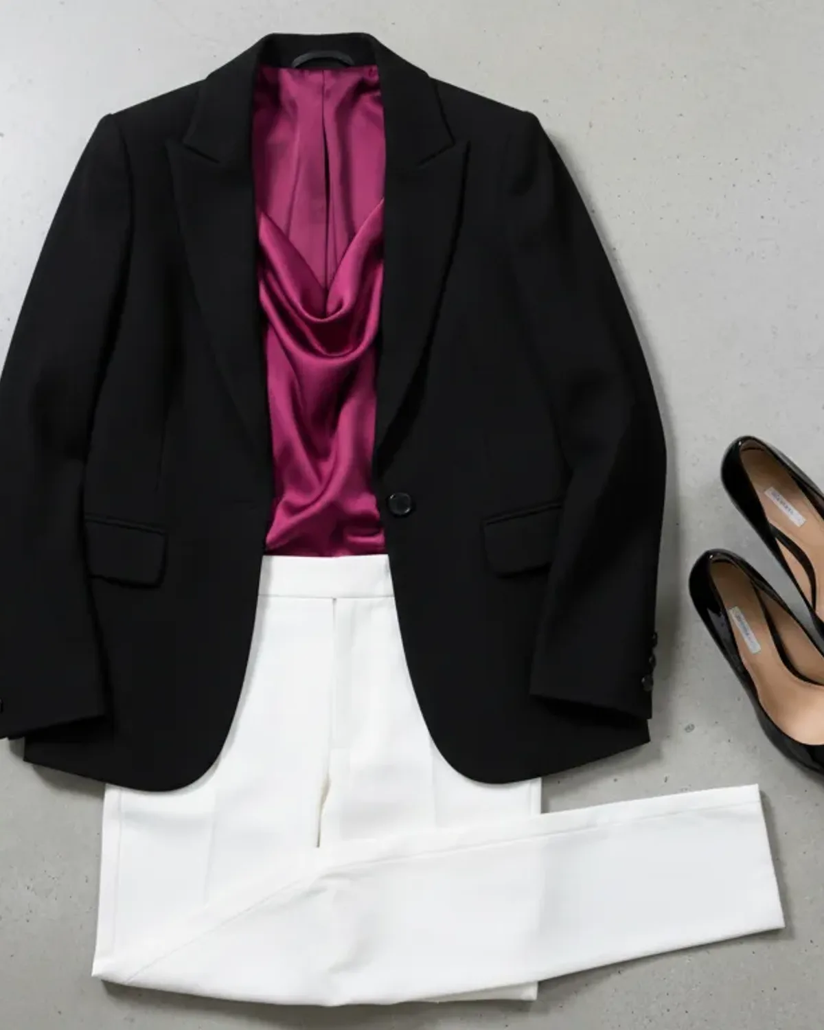 Bright Winter weekend outfit flat lay: hot-pink knit, dark denim and white sneakers.