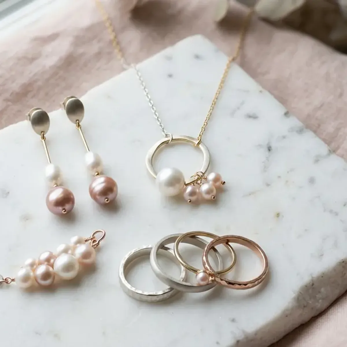 Light Summer metals still life: Silver, white gold, soft rose gold.